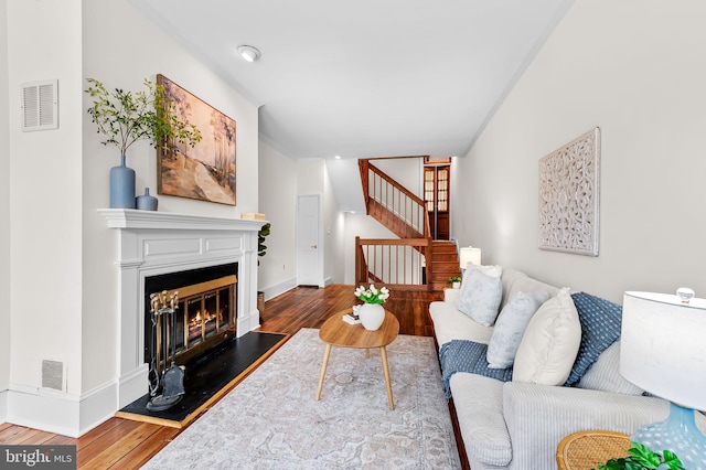 living room featuring wood-type flooring and ornamental molding