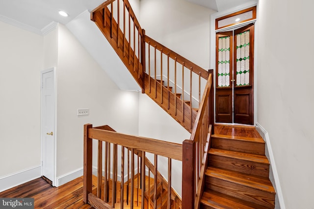 stairs with hardwood / wood-style flooring and ornamental molding