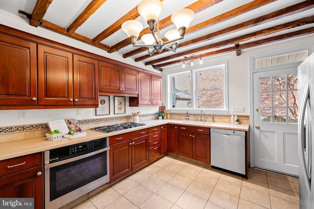 kitchen with tasteful backsplash, appliances with stainless steel finishes, and decorative light fixtures