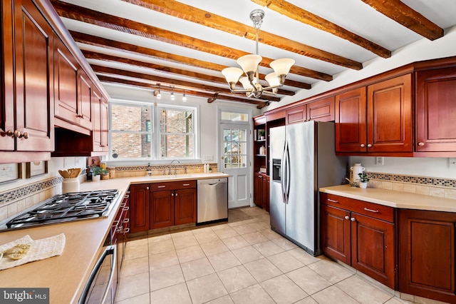 kitchen featuring stainless steel appliances, tasteful backsplash, pendant lighting, and beam ceiling