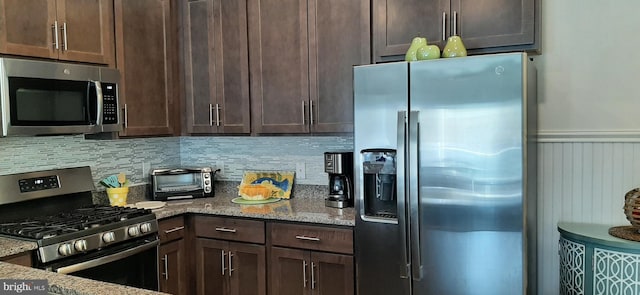 kitchen with light stone countertops, decorative backsplash, stainless steel appliances, and dark brown cabinets