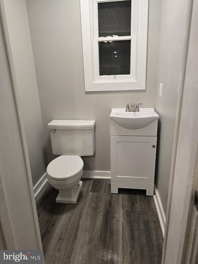 bathroom featuring toilet, vanity, and hardwood / wood-style flooring