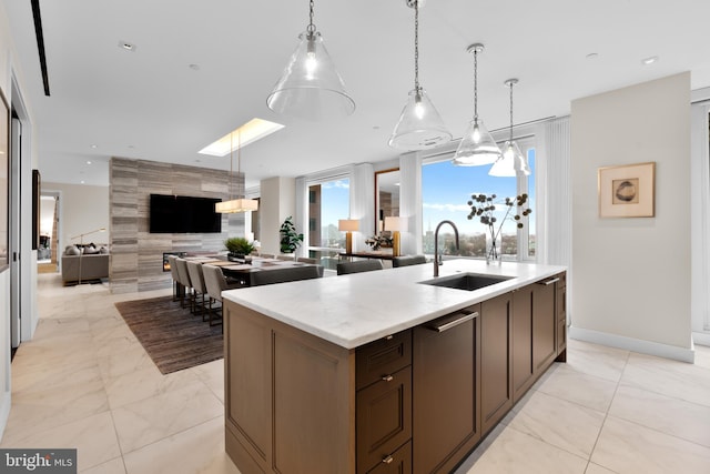 kitchen with sink, pendant lighting, and a kitchen island with sink