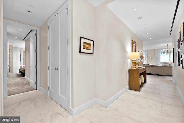 hallway with an inviting chandelier