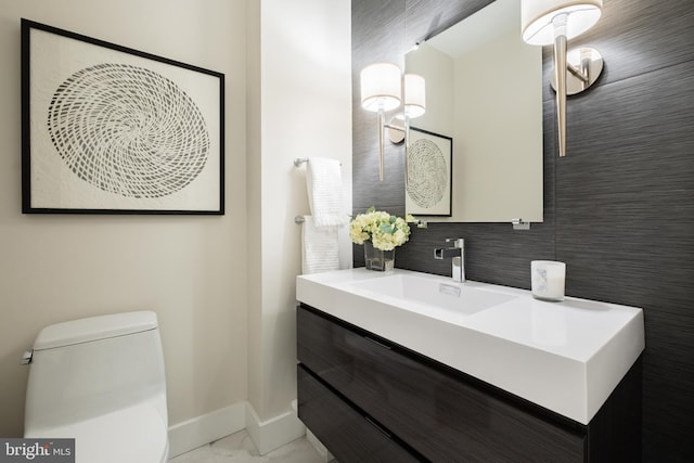 bathroom featuring vanity, backsplash, and toilet