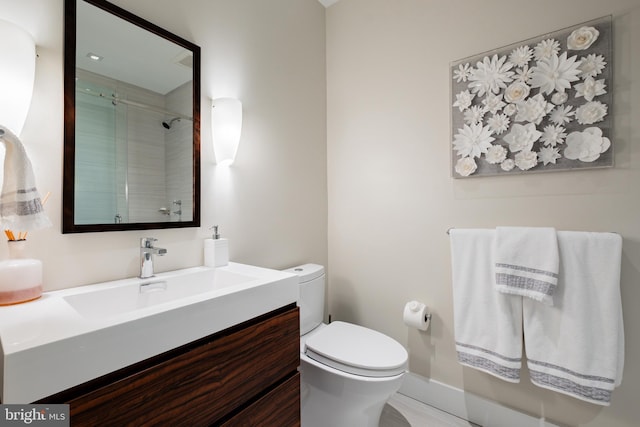 bathroom featuring vanity, an enclosed shower, and toilet