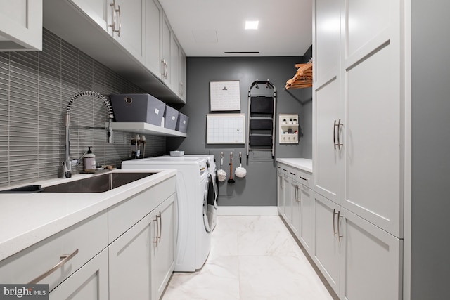 laundry room featuring cabinets, sink, and washing machine and clothes dryer