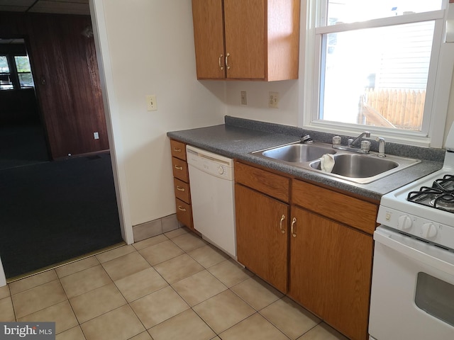 kitchen featuring white appliances, sink, and light tile patterned floors