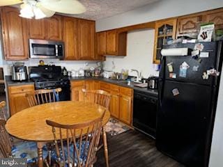 kitchen featuring black appliances, sink, ceiling fan, a textured ceiling, and dark wood-type flooring