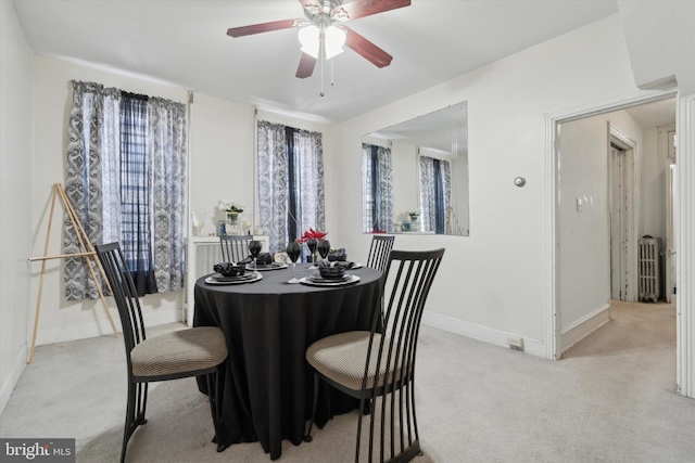 carpeted dining room with ceiling fan and radiator heating unit