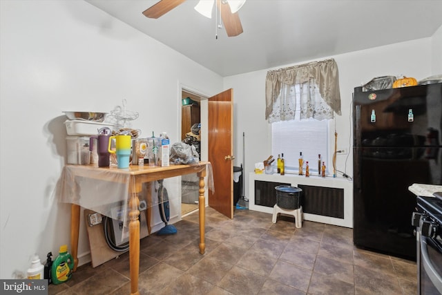 kitchen featuring range, ceiling fan, and black refrigerator