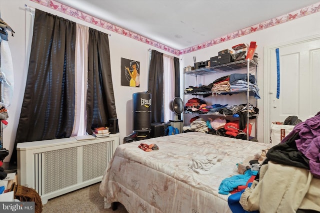 bedroom with radiator heating unit and carpet