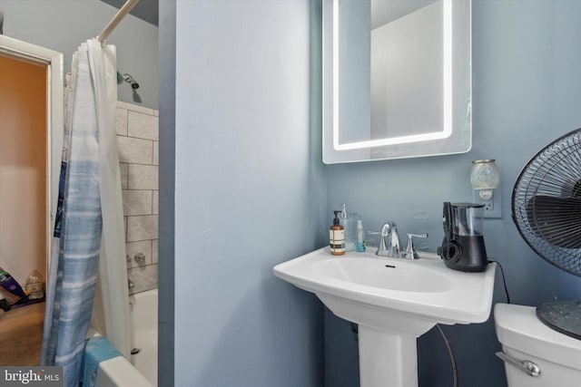 full bathroom with sink, shower / bath combo, and toilet