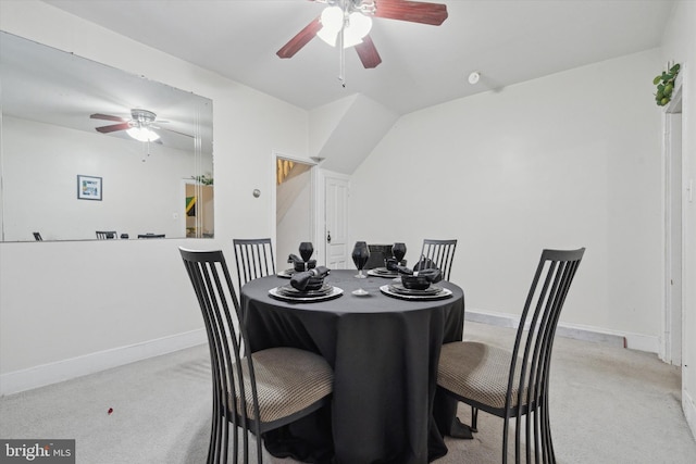 carpeted dining area with vaulted ceiling and ceiling fan