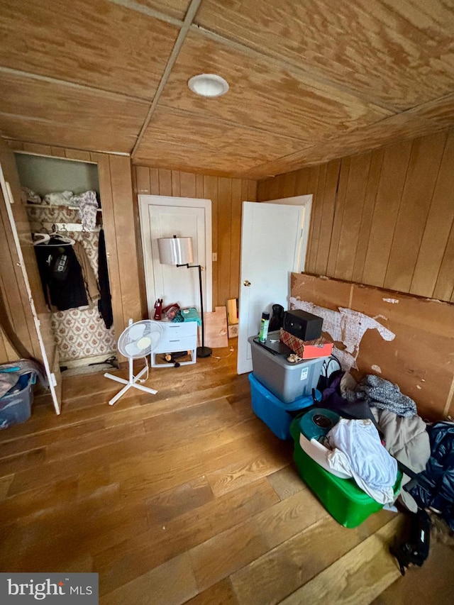 interior space with hardwood / wood-style flooring, wooden ceiling, and wood walls