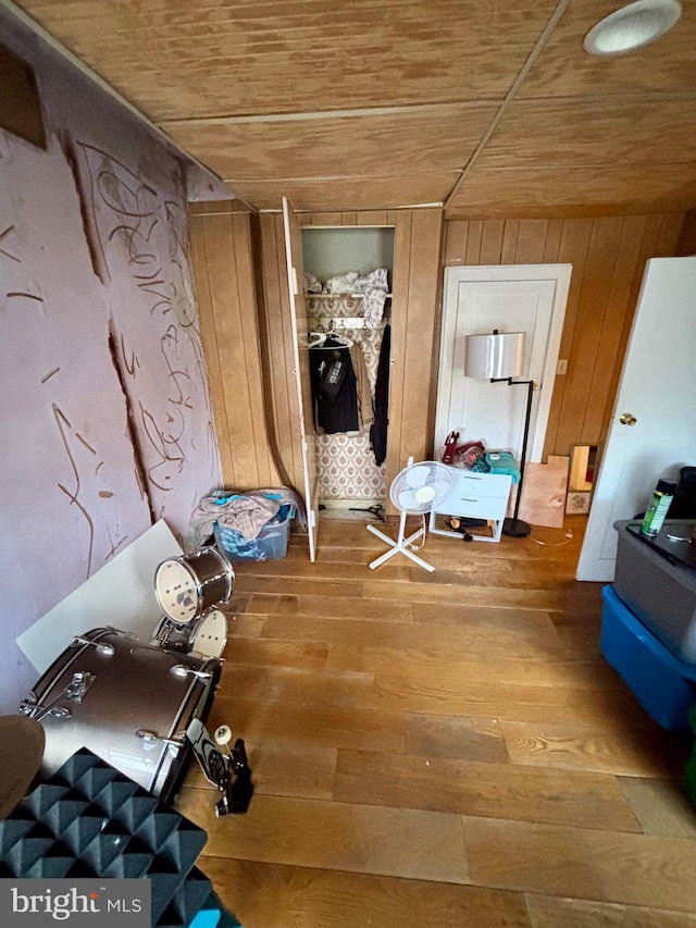 hall with wood walls, hardwood / wood-style floors, and wood ceiling