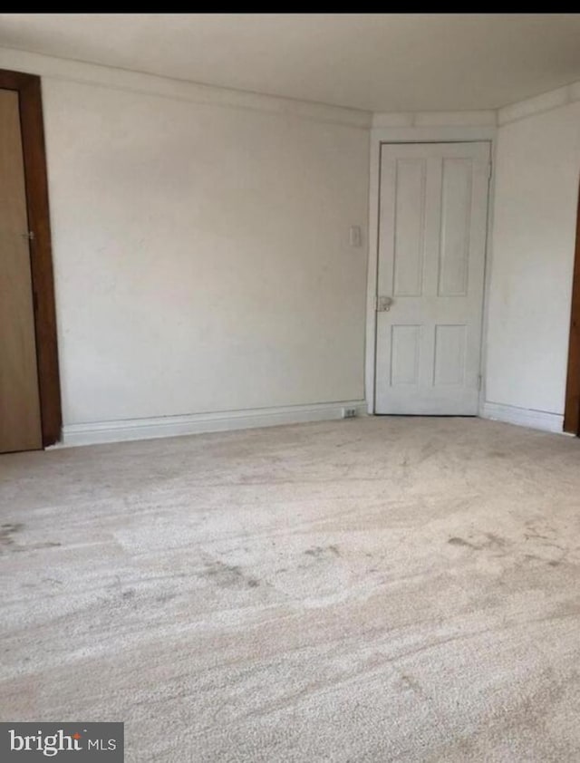 carpeted spare room featuring crown molding