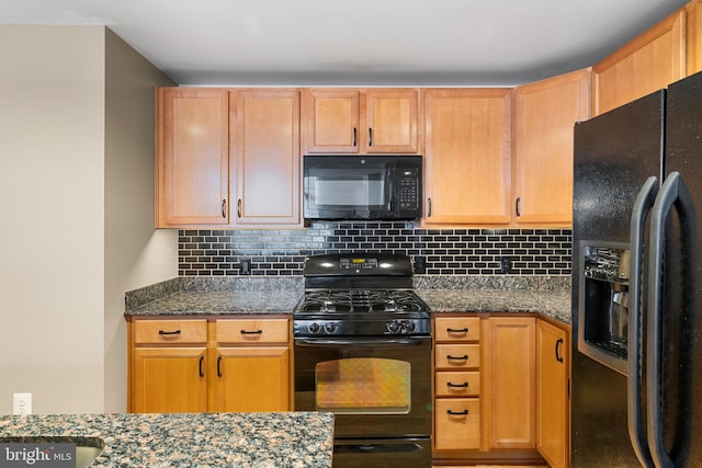 kitchen featuring black appliances, light brown cabinetry, dark stone counters, and tasteful backsplash