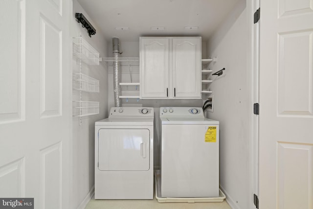 washroom featuring cabinets and independent washer and dryer