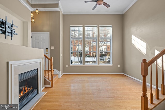 unfurnished living room with light hardwood / wood-style flooring, ceiling fan, and ornamental molding