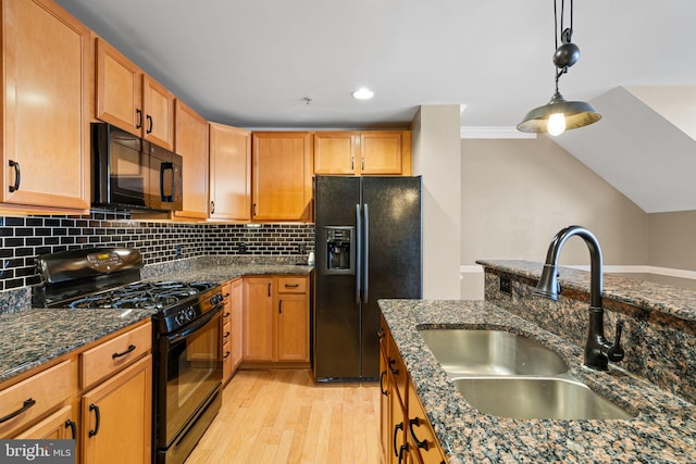 kitchen with backsplash, black appliances, sink, hanging light fixtures, and dark stone countertops