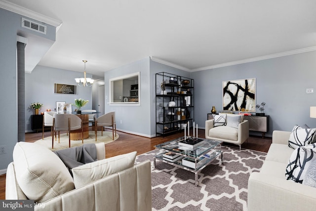 living room featuring dark hardwood / wood-style flooring, an inviting chandelier, and crown molding