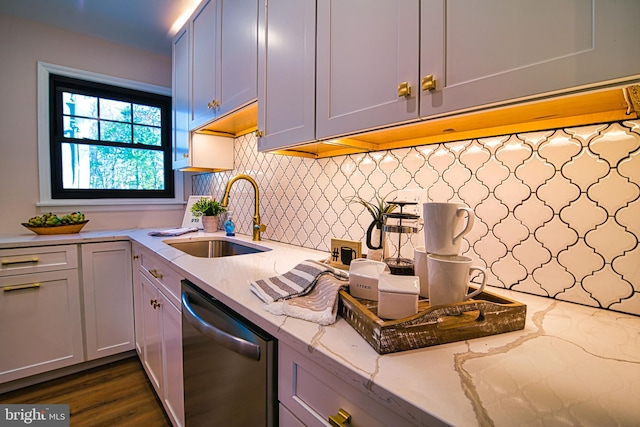 kitchen featuring sink, light stone counters, stainless steel dishwasher, backsplash, and dark hardwood / wood-style floors