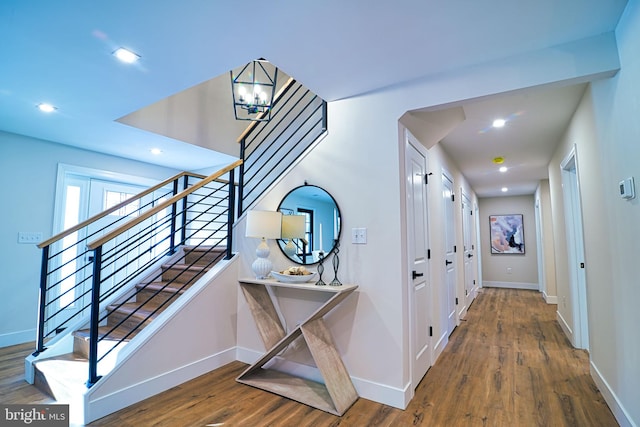 hallway with a chandelier and wood-type flooring