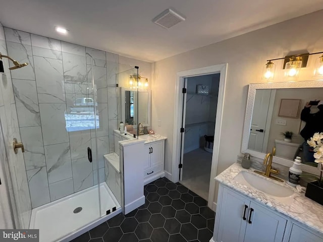 bathroom featuring tile patterned flooring, an enclosed shower, and vanity