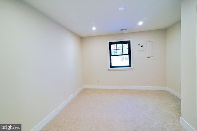 unfurnished room with electric panel and light carpet