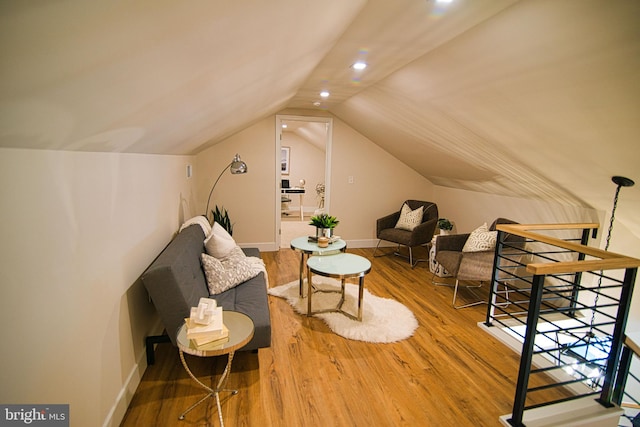 sitting room with lofted ceiling and wood-type flooring