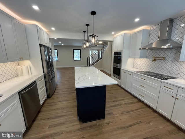 kitchen featuring stainless steel appliances, a center island, dark hardwood / wood-style floors, white cabinetry, and wall chimney range hood