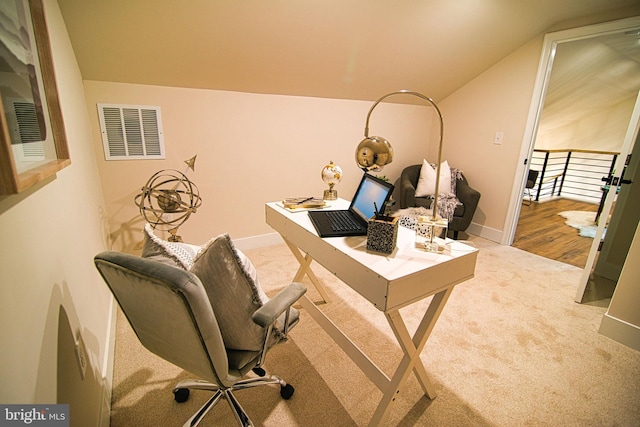 carpeted home office with lofted ceiling