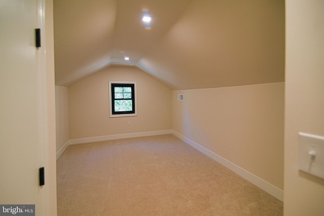 bonus room featuring light colored carpet and vaulted ceiling