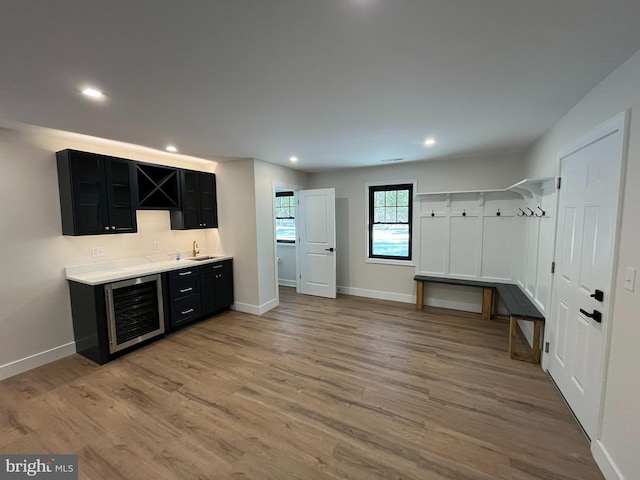 interior space featuring sink, wine cooler, and light hardwood / wood-style flooring