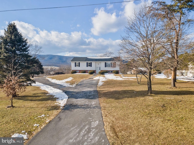 bi-level home featuring a mountain view and a front lawn