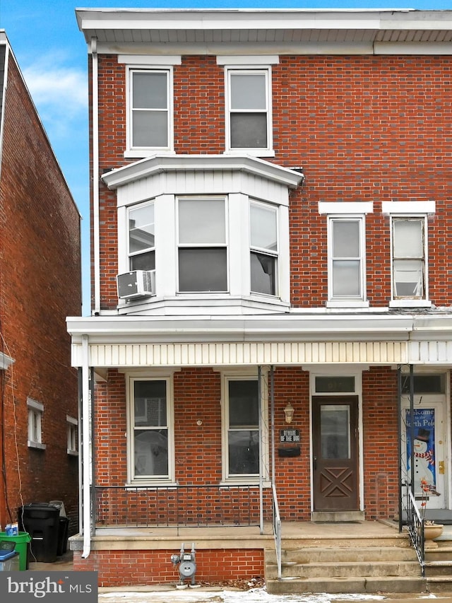 townhome / multi-family property featuring cooling unit and covered porch