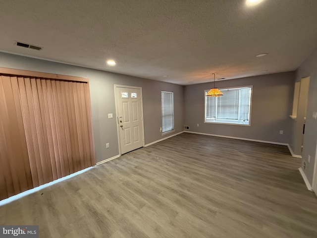 foyer entrance with wood-type flooring and a textured ceiling