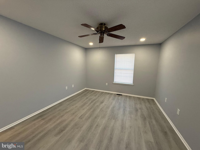 unfurnished room with ceiling fan, a textured ceiling, and light hardwood / wood-style flooring