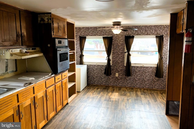 kitchen featuring ceiling fan, stainless steel oven, and dark hardwood / wood-style flooring