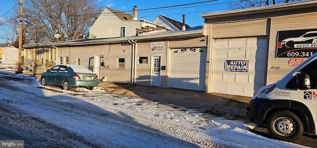 snow covered property with a garage