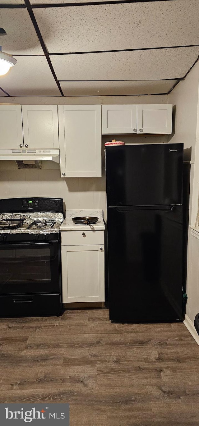 kitchen featuring white cabinetry, dark wood-type flooring, and black appliances