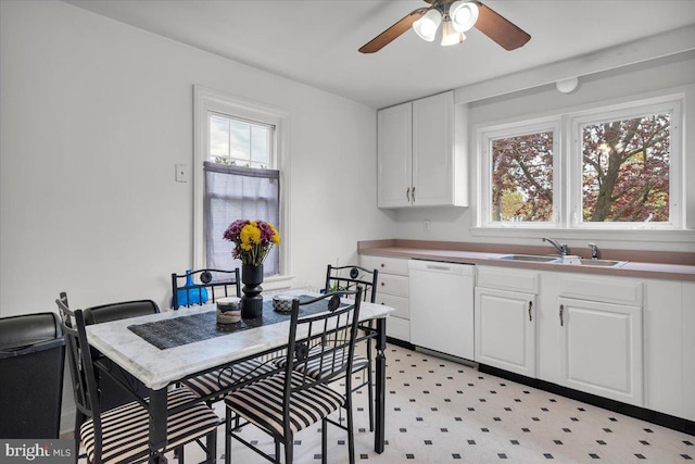 kitchen featuring white dishwasher, white cabinetry, and sink