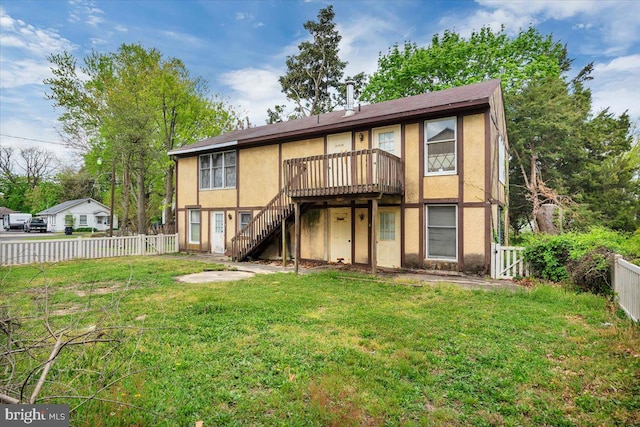 rear view of property featuring a yard and a deck