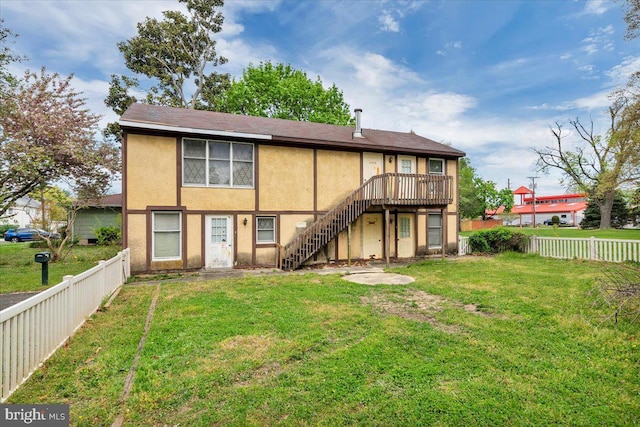 back of house with a lawn and a deck