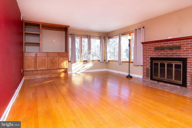 unfurnished living room featuring wood-type flooring and a fireplace