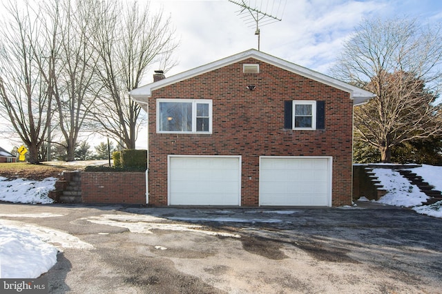 view of snowy exterior with a garage