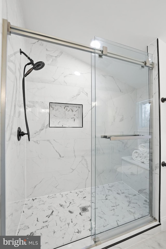 bathroom featuring a shower with door