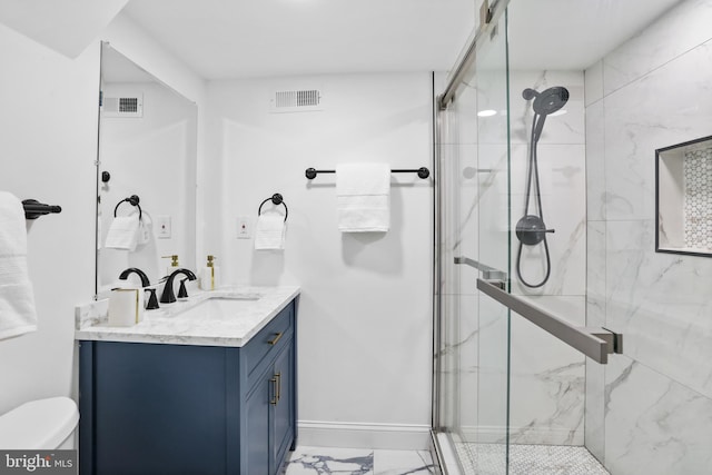 bathroom featuring toilet, vanity, and a shower with shower door