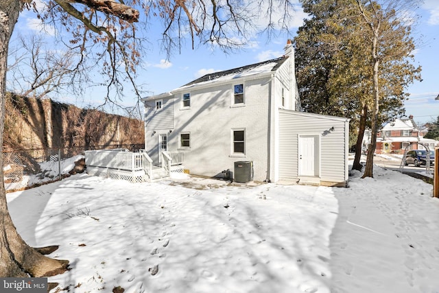 snow covered property featuring a wooden deck and central AC unit